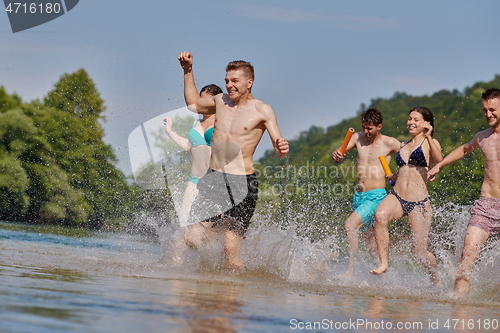 Image of group of happy friends having fun on river