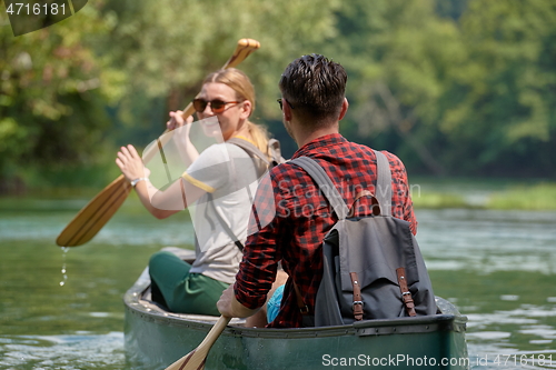 Image of friends are canoeing in a wild river