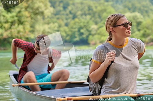 Image of friends are canoeing in a wild river