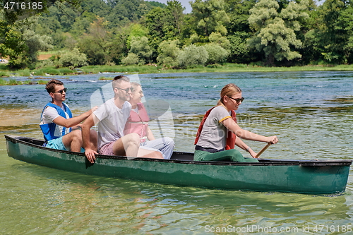 Image of Group adventurous explorer friends are canoeing in a wild river