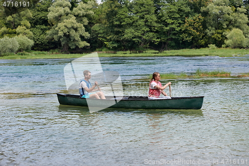 Image of friends are canoeing in a wild river