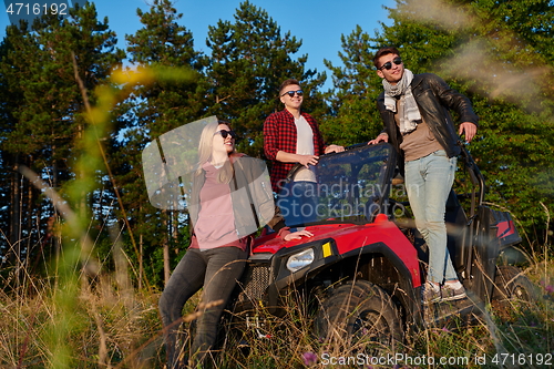 Image of group young happy people enjoying beautiful sunny day while driving a off road buggy car