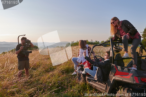 Image of cameramen with professional equipment film a group of young people