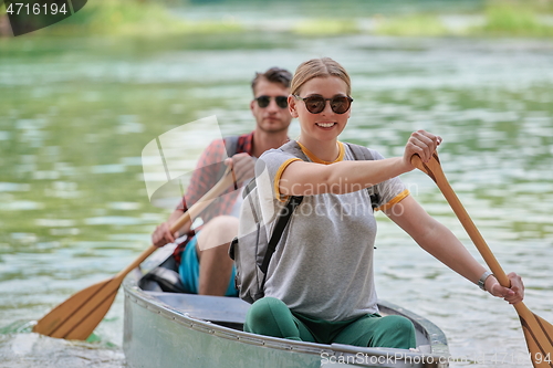 Image of friends are canoeing in a wild river