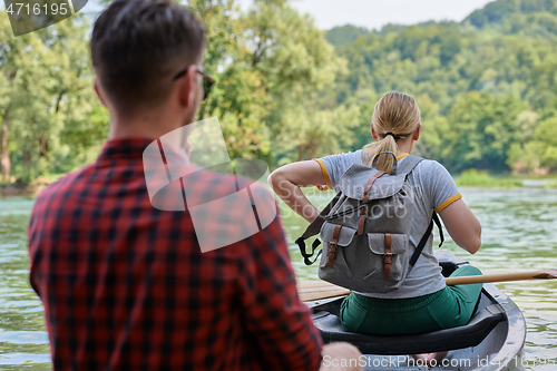 Image of friends are canoeing in a wild river