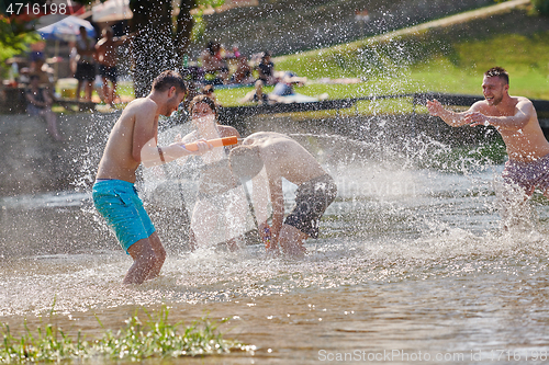 Image of group of happy friends having fun on river