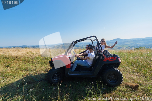 Image of group young happy people enjoying beautiful sunny day while driving a off road buggy car