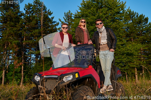 Image of group young happy people enjoying beautiful sunny day while driving a off road buggy car