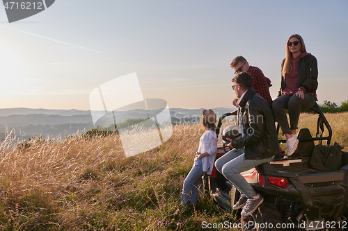 Image of group young happy people enjoying beautiful sunny day while driving a off road buggy car