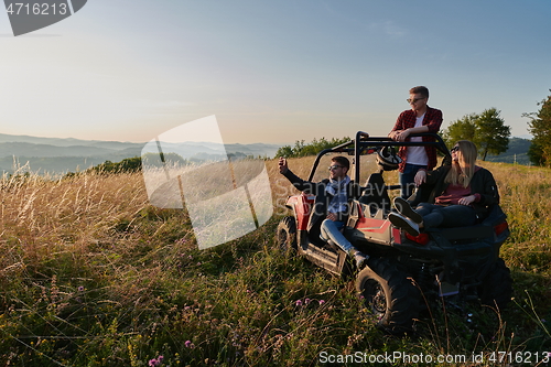 Image of group young happy people enjoying beautiful sunny day while driving a off road buggy car