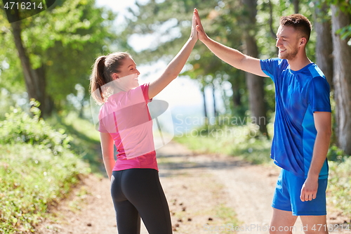 Image of couple enjoying in a healthy lifestyle while jogging on a country road