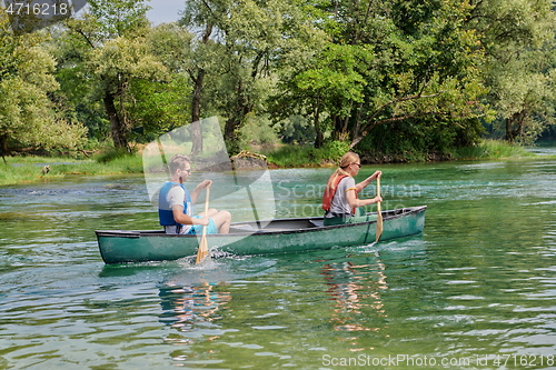 Image of friends are canoeing in a wild river