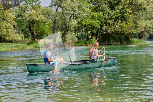 Image of friends are canoeing in a wild river