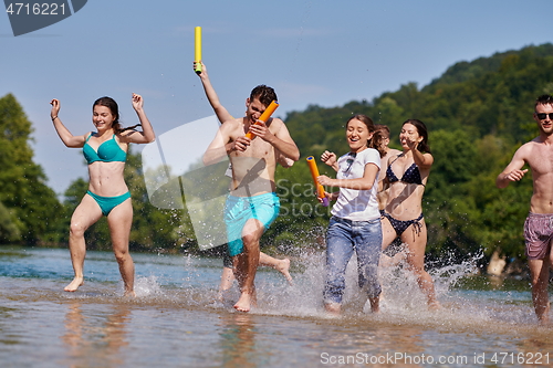 Image of group of happy friends having fun on river