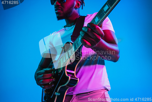 Image of Young african-american jazz musician playing the guitar