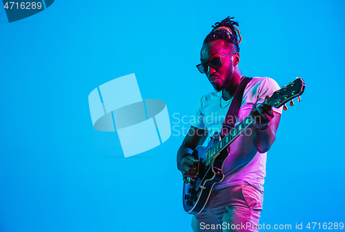 Image of Young african-american jazz musician playing the guitar