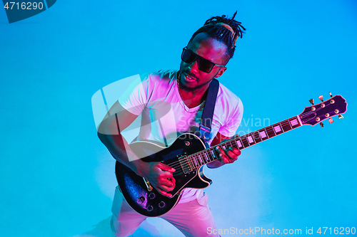 Image of Young african-american jazz musician playing the guitar