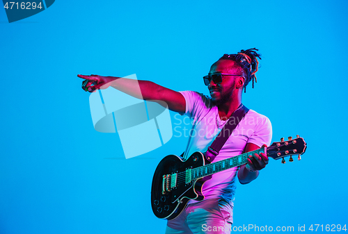 Image of Young african-american jazz musician playing the guitar