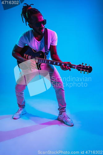 Image of Young african-american jazz musician playing the guitar