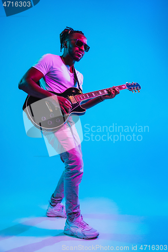 Image of Young african-american jazz musician playing the guitar