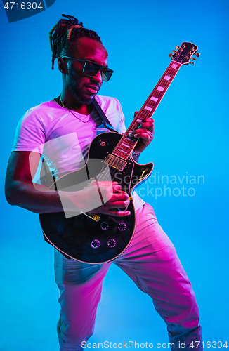 Image of Young african-american jazz musician playing the guitar