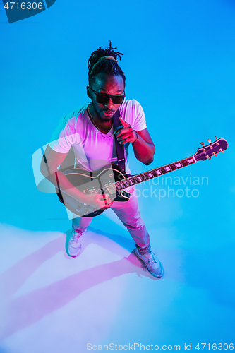 Image of Young african-american jazz musician playing the guitar