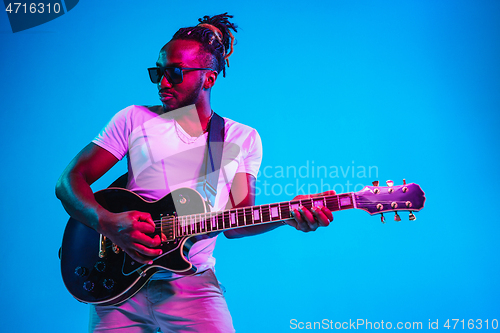 Image of Young african-american jazz musician playing the guitar