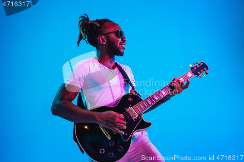 Image of Young african-american jazz musician playing the guitar