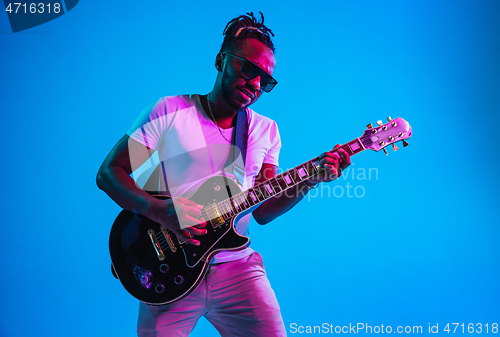 Image of Young african-american jazz musician playing the guitar