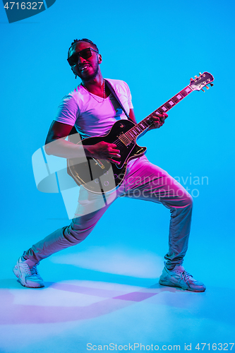 Image of Young african-american jazz musician playing the guitar