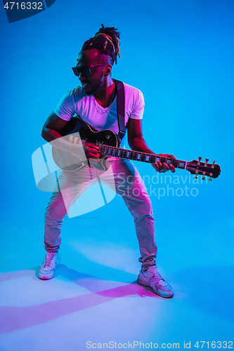 Image of Young african-american jazz musician playing the guitar