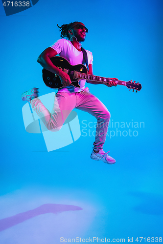 Image of Young african-american jazz musician playing the guitar