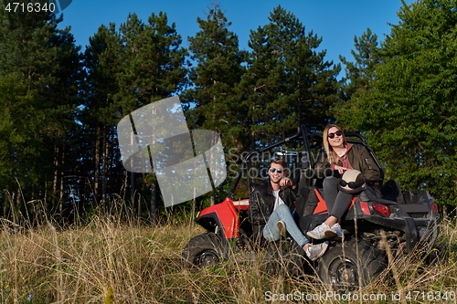 Image of couple enjoying beautiful sunny day while driving a off road buggy