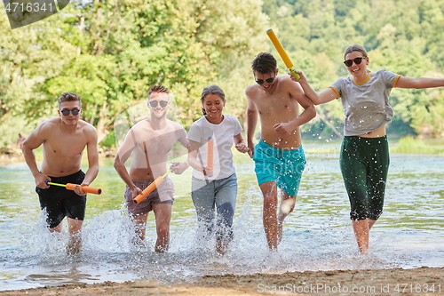 Image of group of happy friends having fun on river