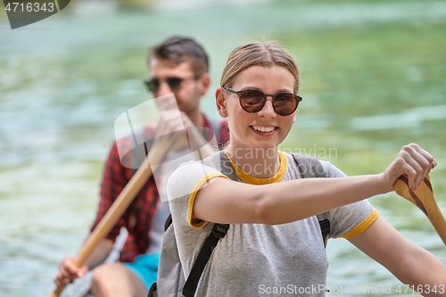 Image of friends are canoeing in a wild river