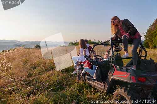 Image of group young happy people enjoying beautiful sunny day while driving a off road buggy car