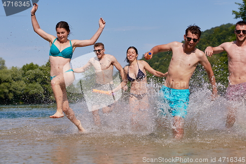 Image of group of happy friends having fun on river