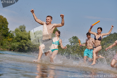 Image of group of happy friends having fun on river