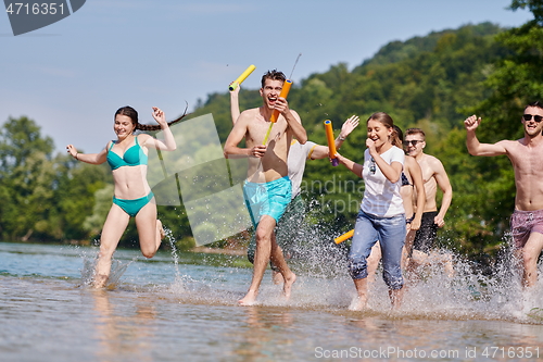 Image of group of happy friends having fun on river