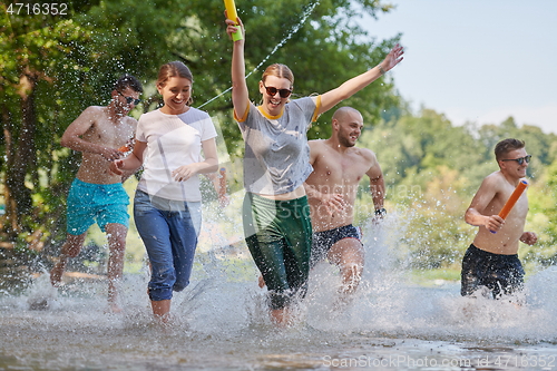 Image of group of happy friends having fun on river