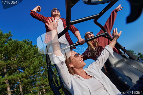 Image of group young happy people enjoying beautiful sunny day while driving a off road buggy car