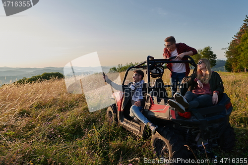 Image of group young happy people enjoying beautiful sunny day while driving a off road buggy car