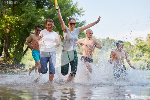 Image of group of happy friends having fun on river