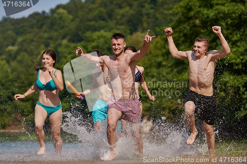 Image of group of happy friends having fun on river