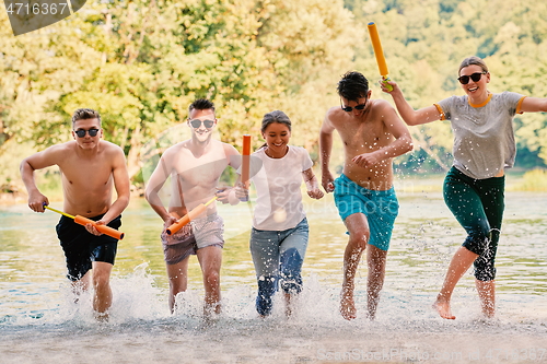 Image of group of happy friends having fun on river