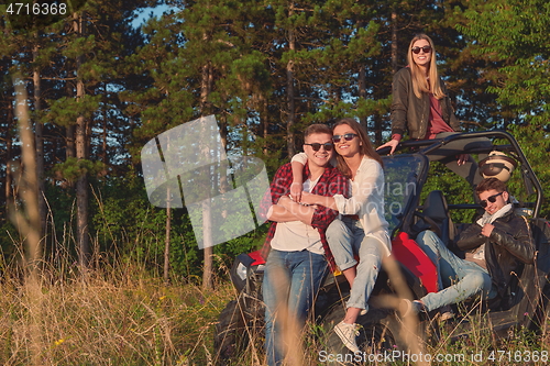 Image of group young happy people enjoying beautiful sunny day while driving a off road buggy car