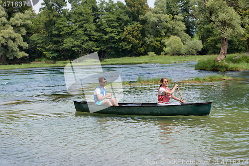 Image of friends are canoeing in a wild river