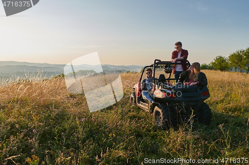 Image of group young happy people enjoying beautiful sunny day while driving a off road buggy car