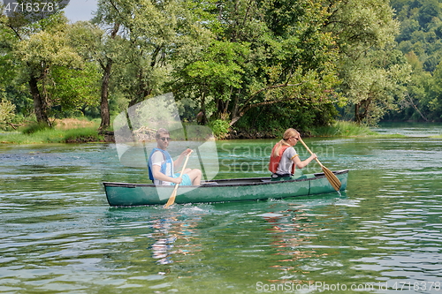 Image of friends are canoeing in a wild river