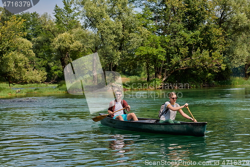 Image of friends are canoeing in a wild river